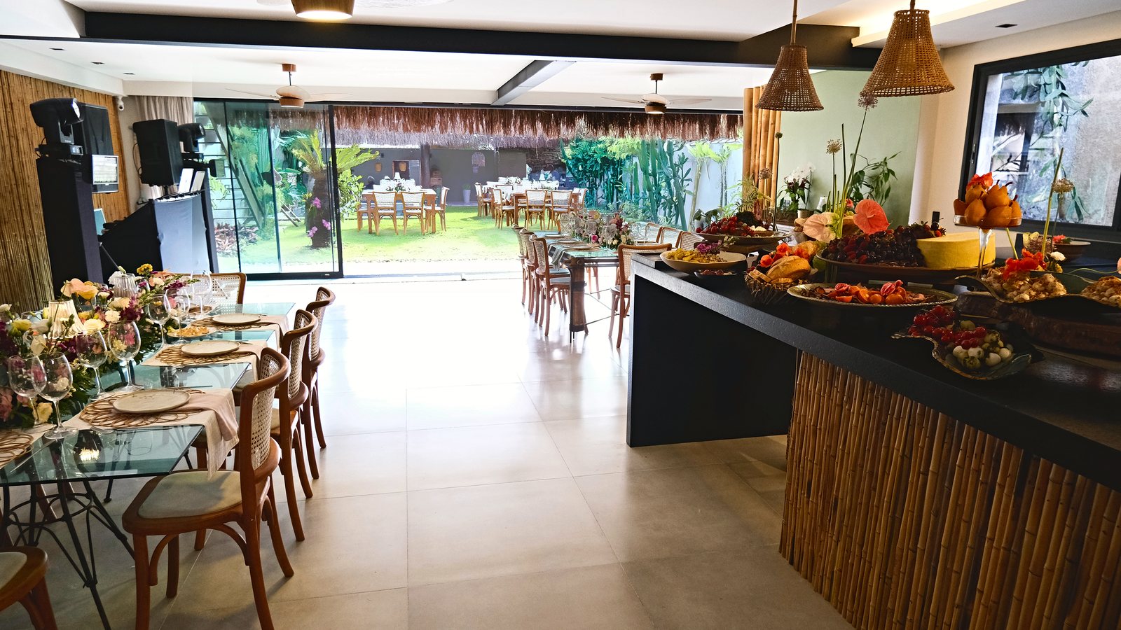 Salão da Pa'ra Oka montado para evento corporativo, com mesa posta, buffet e vista para o jardim